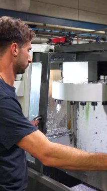 Cnc fabrikasındaki plastik parçaları şekillendirmek için mekanik makine kullanan bir adam