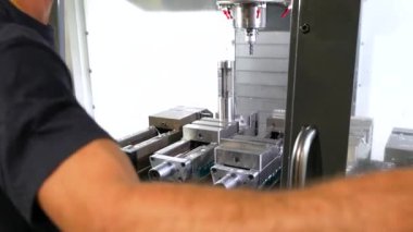 Plastik parçaları üretmek için makineyi kullanan bir erkek işçinin eli yakın plan.