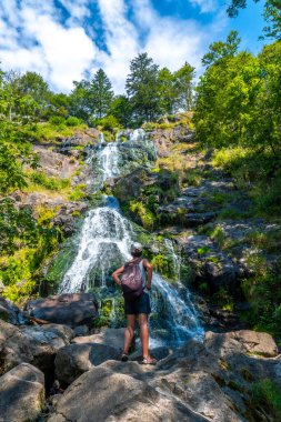 Almanya 'daki Kara Orman' daki Todtnau şelalesinde yazın keyfini çıkaran bir yürüyüşçü.