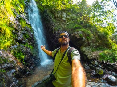 Man tourist hiker in summer at Todtnau waterfall in Black Forest in Germany clipart