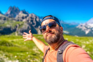 Tre cime di lavaredo 'nun güzel manzarasında kollarını açmış selfie çeken bir sırt çantası, dolomitler. İtalyan Dolimitleri 'nde yaz tatili. İtalya