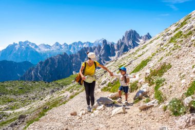 Turistler yaz yürüyüşünün tadını çıkarıyorlar İtalyan dolomitlerinde, arka planda tre cime di lavaredo zirveleri ile