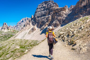 Güneşli bir yaz gününün tadını çıkaran kadın yürüyüşçü dolomitlerdeki tre cime di lavaredo 'nun nefes kesici dağ manzarasını keşfediyor.