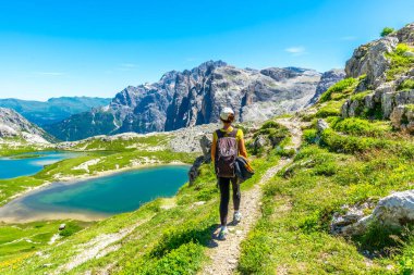 Yaz boyunca İtalyan dolomitlerindeki Tre cime di lavaredo ve alp göllerinin manzarasının tadını çıkaran bir turist. Laghi dei Piani