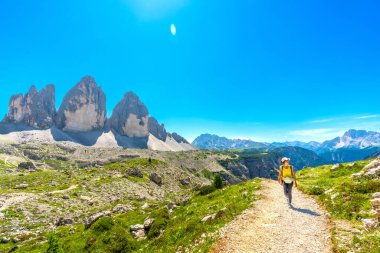 Dolomitlerin sembolü olan Tre cime di lavaredo yakınlarındaki bir dağ yolunda yürüyen bir turist, bir unesco dünya mirası alanı.