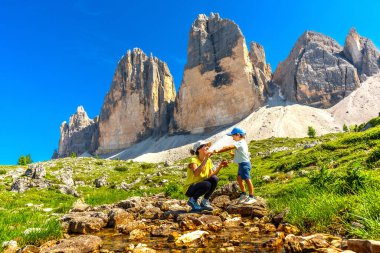 Anne ve oğul İtalyan dolomitlerinin yanında oynuyorlar. Arka planda Tre cime di lavaredo ile güzel bir yaz günü.