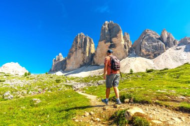 Turist, yazın dolomitlerin nefes kesen zirveleri arasında Tre cime di lavaredo patikasında manzaralı bir yürüyüş yapıyor.