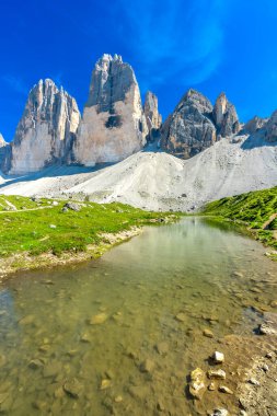 Kristal berrak alp gölü İtalyan dolomitlerinde güneşli bir yaz gününde görkemli Tre cime di lavaredo zirvelerini yansıtıyor.