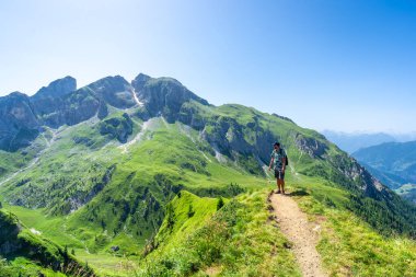 Turist yaz aylarında dolomitlerin çarpıcı zirveleriyle çevrili giau geçidinde yürüyüş yaparken nefes kesici manzaranın tadını çıkarıyor.