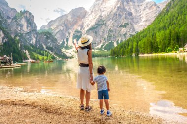 Anne, yaz aylarında İtalyan dolomitlerinde oğlunun elini tutarken manzarayı işaret ediyor.