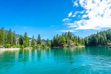 Sersemletici turkuaz sular, yemyeşil ormanları ve İtalyan dolomitlerindeki pitoresk göl braylerinde bir oteli yansıtıyor.