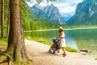 Bebek arabasıyla gezen bir turist nefes kesici bir dağ manzarası içinde dolomite 'lar, İtalya, yaz tatilinin tadını çıkarıyor.