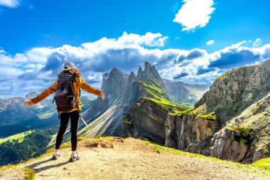 Kolları açık yürüyen yürüyüşçü Seceda 'nın nefes kesici manzarasının tadını çıkarıyor, dolomitler, İtalya