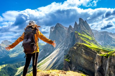 İtalya 'daki Val di Funes' da yaz maceraları sırasında sırt çantalı gezgin, odle sıradağlarının nefes kesici manzarasının keyfini çıkarıyor.