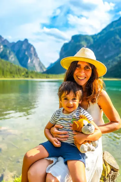 Mutlu anne ve oğul, dolomitlerde muhteşem dağ manzaralı Dobbiaco Gölü 'nde yaz tatilinin tadını çıkarıyorlar.