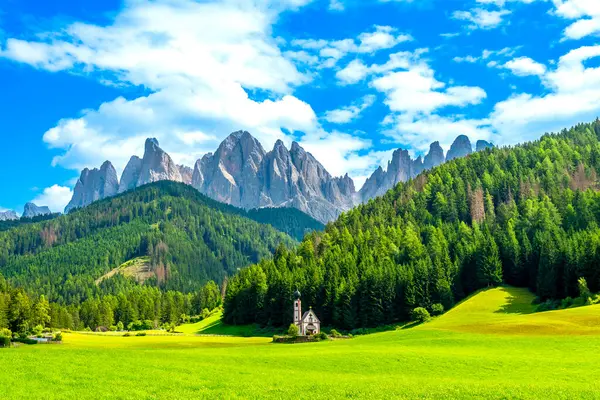 Saint Magdalena Kilisesi ve İtalyan dolomitlerindeki tuhaf dağ silsilesiyle Val di Funes vadisinin manzarası.