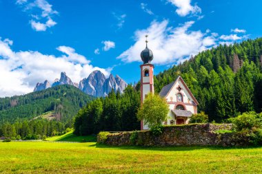 Scenic summer landscape with st. Magdalena church in the idyllic valley of val di funes, surrounded by the majestic odle geisler group in the dolomites, italy clipart