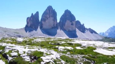 Panoramik. Yürüyüşçüler güneşli bir yaz günü ikonik tre cime di lavaredo zirvelerinin yanındaki manzaralı dağ yolunda İtalyan dolomitlerinin tadını çıkarıyorlar.