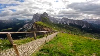 Güneşli bir yaz gününde, İtalyan dolomitlerinde Seceda dağlarının görkemli zirvelerinin altındaki yemyeşil vadilerde yürüyüş izleri.