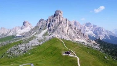 Sıcak yaz güneşinde yıkanan italyan dolomitlerinde passo giau 'nun engebeli tepeleri ve yemyeşil yamaçları sersemletici manzaralar.