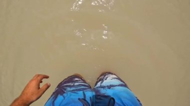 Güneşli bir yaz gününde, soluk kesici dolomitlerle çevrili lago di landro 'nun turkuaz suyunda yüzerken, turist el sallıyor.