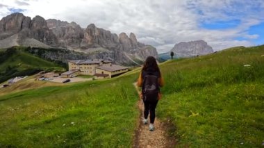 Turistler, nefes kesen manzaralar ve canlı çayırlarla çevrili İtalya 'daki gardenya geçidi yakınlarındaki çarpıcı dolomitler boyunca yaz yürüyüşünün tadını çıkarıyorlar.