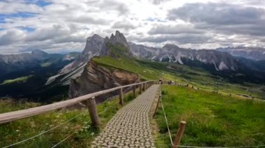 Güneşli bir yaz gününde İtalyan dolomitlerindeki seceda tepeleri ve yeşil çayırlar göz kamaştırıcı.
