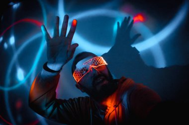 Aydınlatılmış gözlük takan siber punk adam artırılmış gerçeklik teknolojisi kullanarak sanal gerçeklik oyunuyla etkileşime geçiyor.