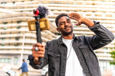 Şehirde çevrimiçi yayınlanırken Afrikalı vlogger hareketi ve göz kırpması