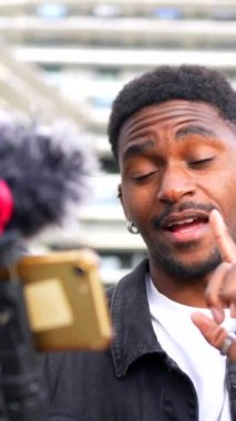 Şehirde çevrimiçi yayınlanırken Afrikalı vlogger hareketi ve göz kırpması