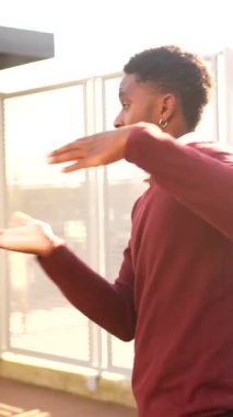 Şehirde dans eden havalı bir Afrikalı adamın yan görüntüsü.