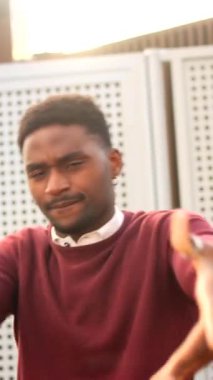 Şehirde dans ederken kameraya el sallayan ve göz kırpan havalı şehir dansçısı.