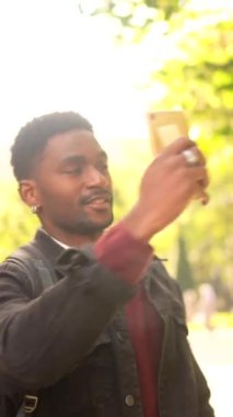 Mutlu Afrikalı adam gün batımının altında fotoğraf çekiyor.