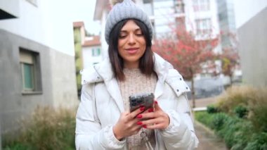 Cep telefonuyla video görüşmesinde gülümseyen mutlu karnavallı genç kadın.