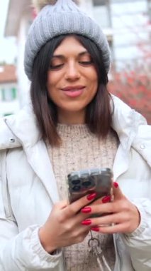Cep telefonuyla video görüşmesinde gülümseyen mutlu karnavallı genç kadın.