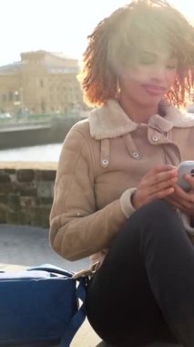 Kentte nehrin kenarında oturan telefonu kullanan Latin bir kadının fotokopi odası.