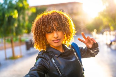 Güzel Latin bir kadının kişisel bakış açısı. Özçekim konuşması. Arka planda günbatımı ile başarı.