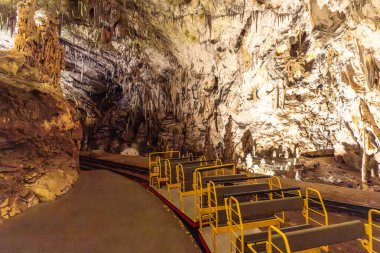 Slovenia 'daki ünlü post-jna mağarasında turistleri bekleyen boş elektrikli tren çarpıcı sarkıtlar ve kaya oluşumları sergiliyor.