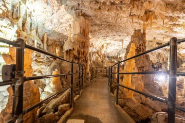 Turistler, nefes kesici sarkıt ve dikit oluşumlarına hayret ederek, post-jna mağarasının aydınlık yürüyüş yollarında tren yolculuğunun keyfini çıkarırlar.