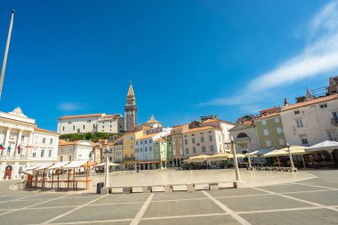 Renkli binalar, canlı mavi bir yaz gökyüzünün altında, Piran, Slovenia 'da tartini meydanında, Adriyatik sahillerinin cazibesini sergiliyor.