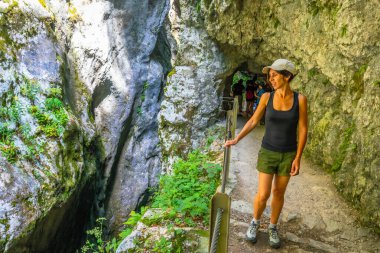 Triglav Ulusal Parkı 'nda Tolmin Vadisi' ni keşfeden kadın turist nefes kesen kaya oluşumlarının ve yemyeşil yeşilliğin tadını çıkarıyor.