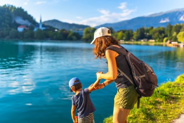 Anne ve oğlu el ele tutuşmuş, gölün turkuaz suyunun tadını çıkarıyorlardı. Arka planda kanayan adada ikonik bir kilise vardı.