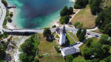 Hava görüntülerinde Vaftizci Aziz John Kilisesi ve Slovenya 'daki Bohinj Gölü üzerinde taş bir köprü sergileniyor.