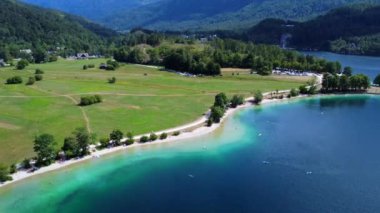 Turistler, yemyeşil yemyeşil bir göl kenarında yazın tadını çıkarıyorlar ve ılık güneşin tadını çıkarıyorlar.