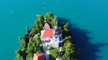 Havadan bakıldığında, Mary Hac Kilisesi 'nin göl kıyısındaki kanaması ve Slovenia' nın göz kamaştırıcı manzarasının altını çizdiği görülüyor.