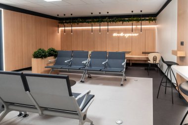 Rahat koltuklar, çalışma alanları ve modern tasarım içeren boş havaalanı salonu, gezginler için rahatlatıcı bir ortam sağlıyor