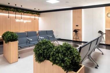 Modern mobilyalar, bitkiler ve yumuşak ışıklandırma ile rahat bekleme alanı gezginler için rahatlatıcı bir atmosfer yaratıyor.