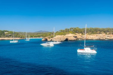 Cala Mondrago doğal parkında, Mallorca 'da, İspanya' da turkuaz sularda yüzen yatlar.