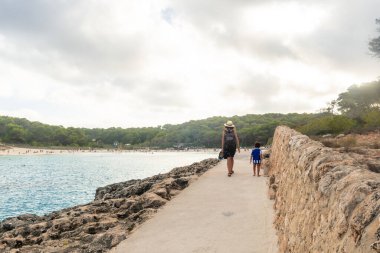 Anne ve oğlu deniz kenarında yürüyor, Mallorca, İspanya 'daki s' amarador plajında tatilin tadını çıkarıyorlar.