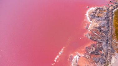 Torrevieja tuz madeninin pembe gölünün hava aracı görüntüsü günbatımında yansıyarak İspanya, Alicia 'da nefes kesici pembe bir manzara yaratıyor.